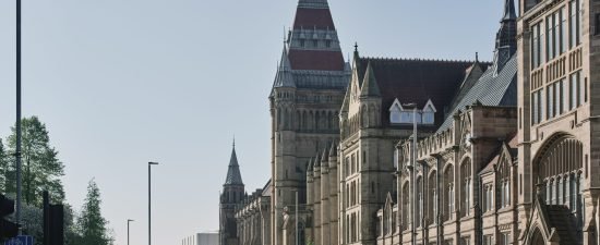 Historic architecture lining a sunlit city street with clear skies above